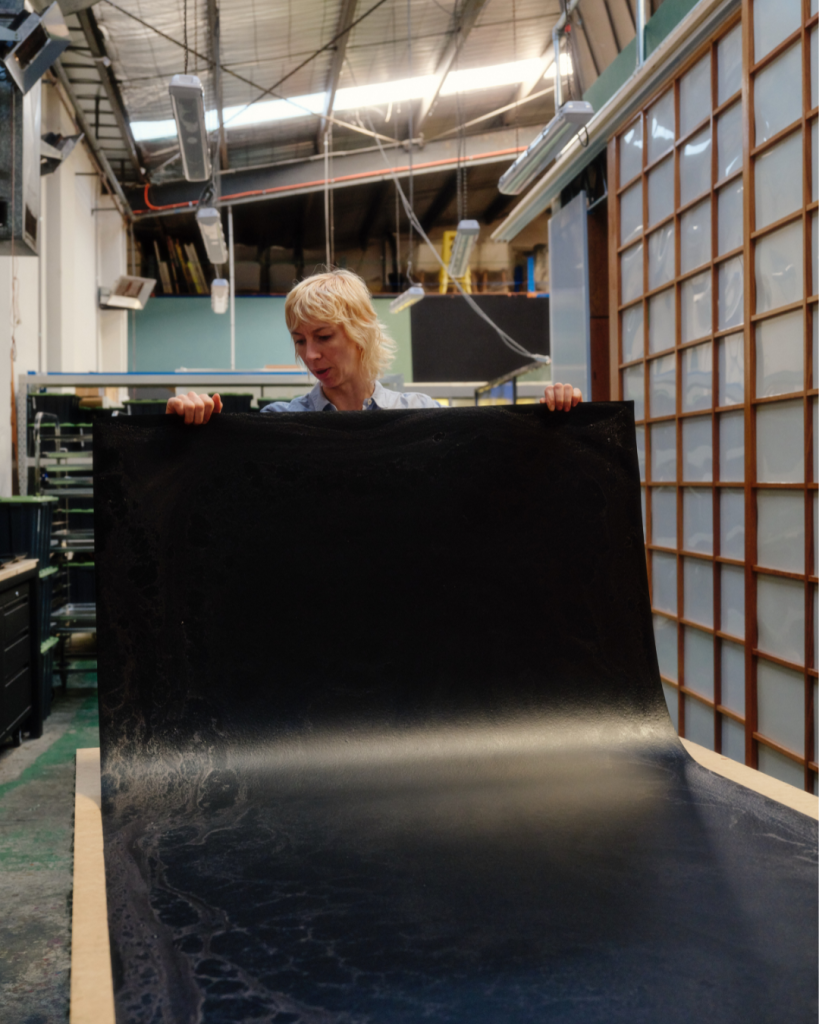 Jessie French from Other Matter holding sheet of Other Matter Leather
